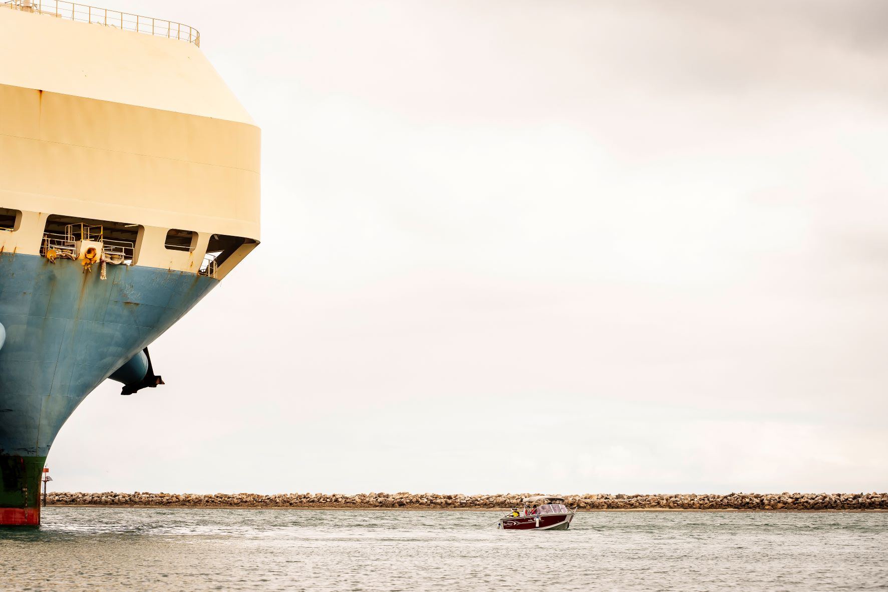 Large container ship on the water near a smaller boat