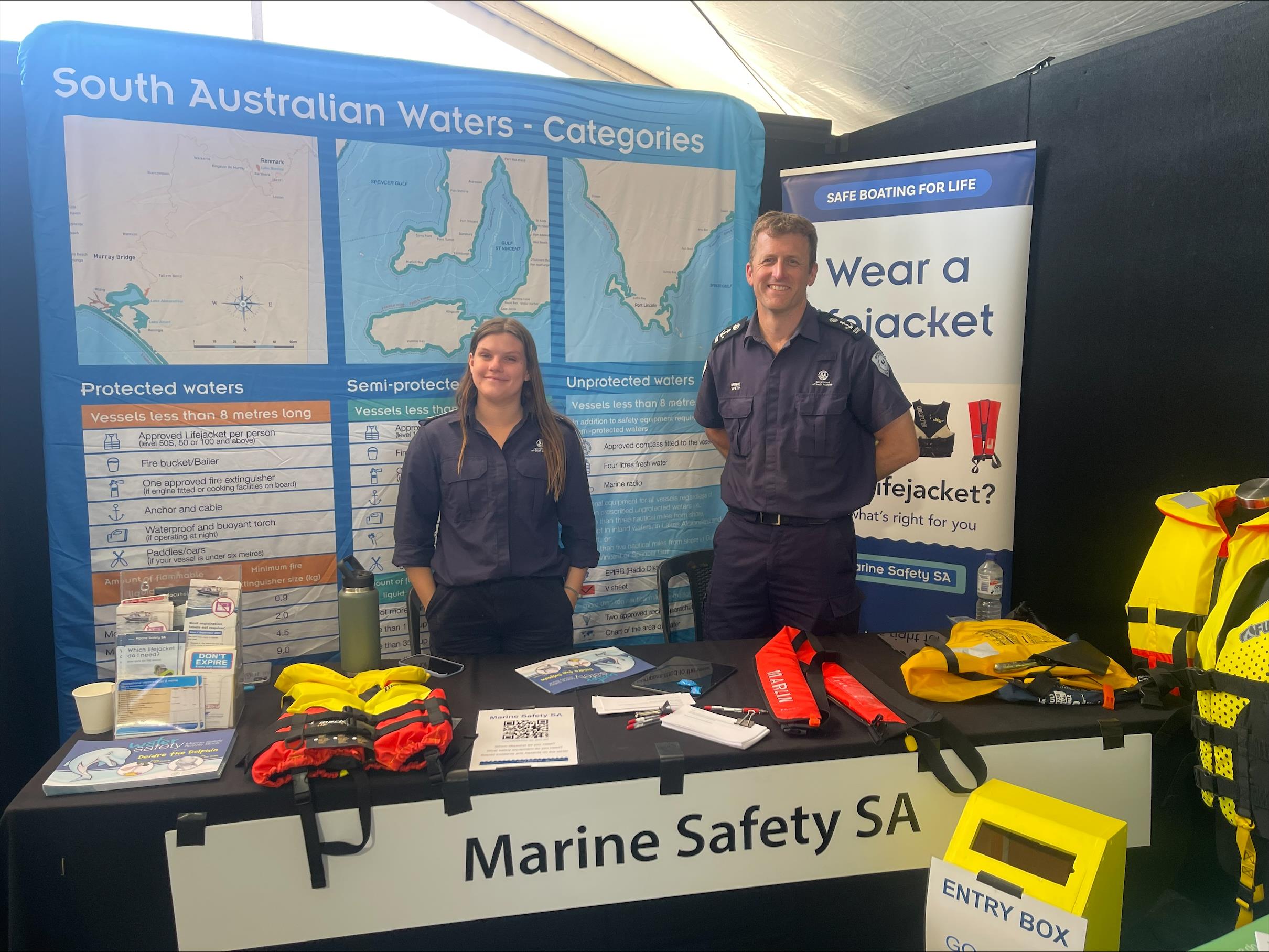 Marine Safety and Compliance staff standing in front of the Marine Safety SA display