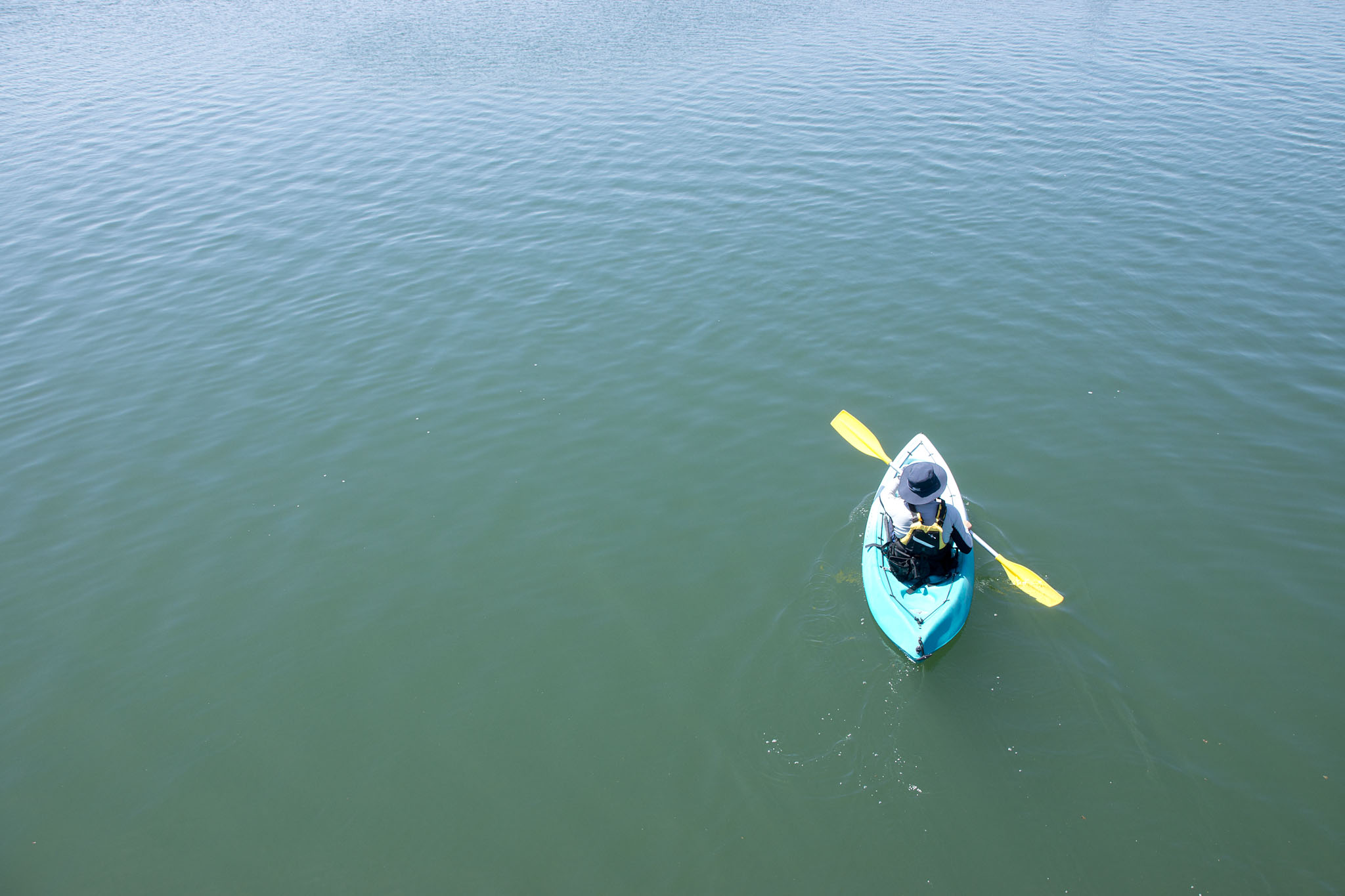 Single kayaker paddling on the water aerial view