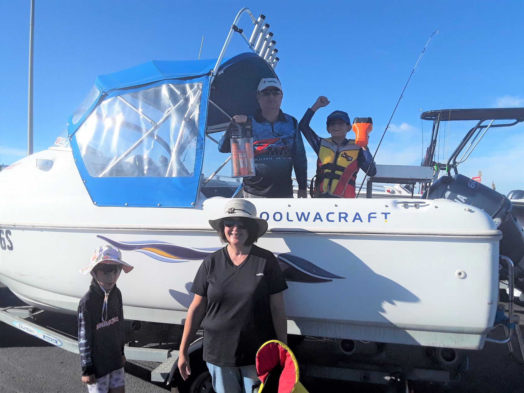 Family next to a boat showing their safety equipment